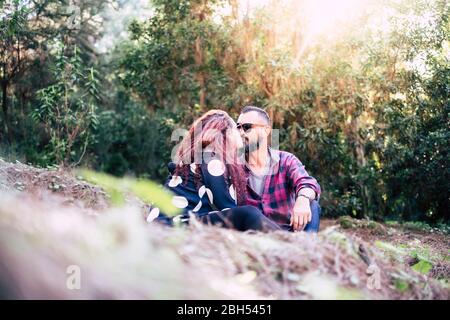 Couple embrassant assis sur l'herbe Banque D'Images