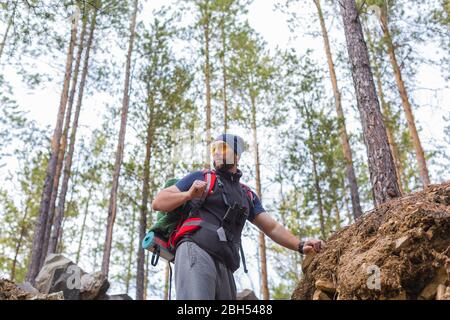 Vue de dessous d'un touriste de randonnée à pied à travers les arbres dans les hautes terres. Mode de vie actif et concept de santé. Banque D'Images
