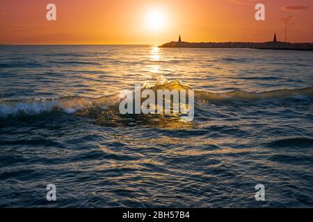 Lever de soleil spectaculaire sur les vagues de la mer. Soleil sur l'horizon, beau lever de soleil sur l'océan et vagues douces éclairées par la lumière du soleil du matin. Banque D'Images