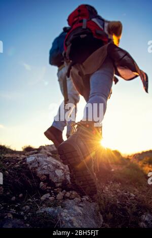 Un couple touristique portant des bottes de randonnée se dresse sur une colline herbeuse dans les Alpes. Banque D'Images