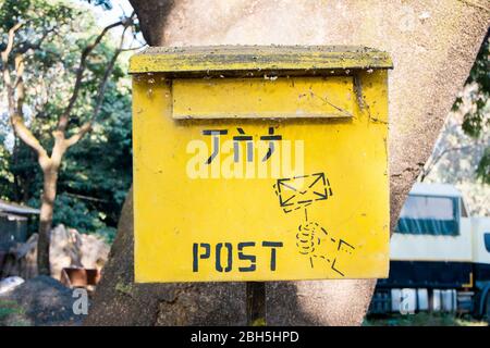 Exemple de lettres de poste en métal jaune, de boîte de courrier, montées sur un arbre. En Ethiopie, Afrique. Banque D'Images