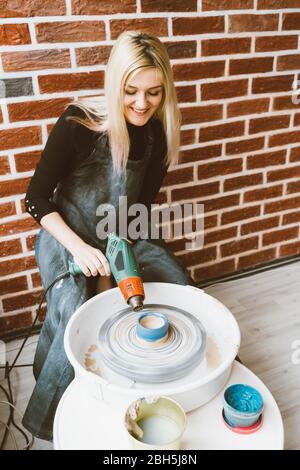 Femme faisant de la poterie céramique sur la roue, soufflez des blancs secs en argile. Concept pour femme en freelance, affaires. Produit artisanal. Gagnez de l'argent supplémentaire, côté Banque D'Images