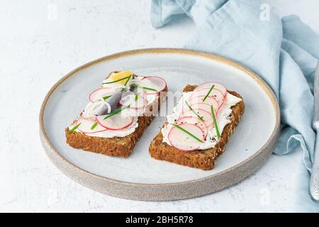 Smorrebrod salé, deux sandwichs traditionnels danois. Pain de seigle noir avec anchois Banque D'Images