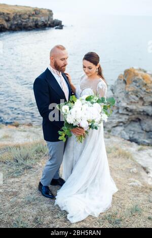 Couple de mariage près de la mer dans le style boho. Banque D'Images