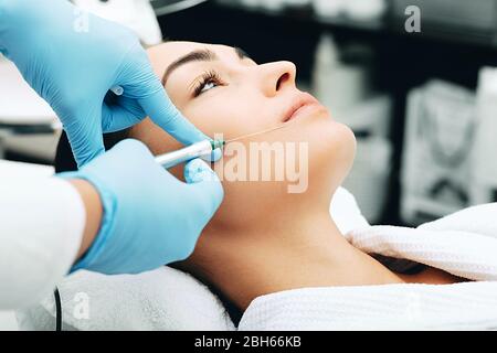 femme ayant des injections faciales pour le visage et l'effet anti-vieillissement. Dépose des plis de lèvre Banque D'Images