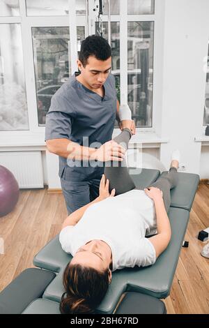 femme pendant les exercices avec son physiothérapeute traitant le dos et la douleur articulaire Banque D'Images