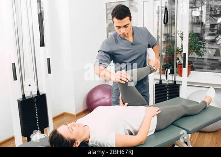 le médecin vérifie l'état des jambes de la femme après le traitement. La patiente devra encore venir pour plusieurs séances de physiothérapie Banque D'Images