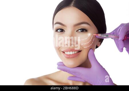 Belle femme asiatique de levage publicité injections. Visage de femme parfaite montrant injection anti age isolated on white Banque D'Images