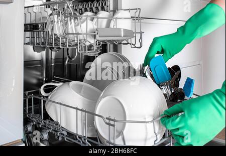 femme prend des plats propres du lave-vaisselle, gros plan. Vaisselle parfaitement lavée. Lave-vaisselle intégré Banque D'Images