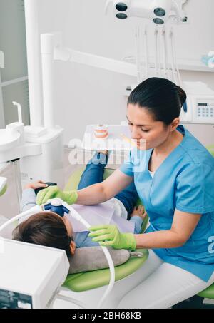 Dentiste pédiatrique faisant une sédation par inhalation à un enfant pendant le traitement des dents à la clinique dentaire. Dentisterie de sédation Banque D'Images