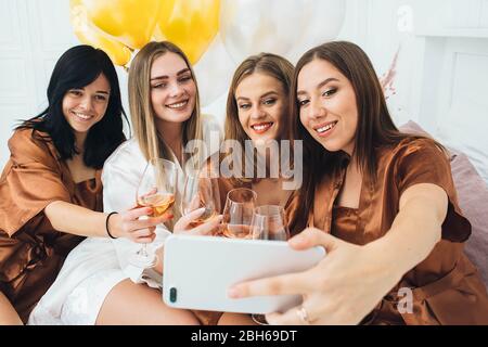 Week-end Bachelorette. Les femmes de chambre qui font du selfie et de la photo amusante, ont une fête fraîche avec de l'alcool Banque D'Images