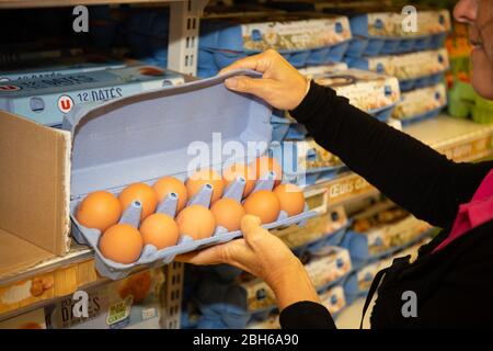 Bordeaux , Aquitaine / France - 04 16 2020 : la femme achète des œufs en vérifiant qu'ils ne sont pas cassés dans un supermarché sur les étagères de produits frais Banque D'Images