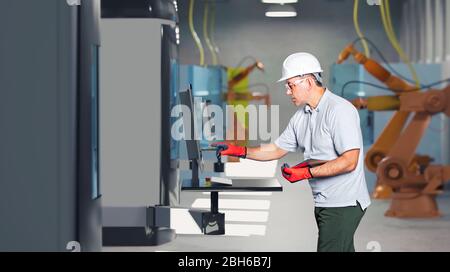 Un technicien masculin pendant la construction de machines ou l'ingénierie mécanique dans une usine de fabrication Banque D'Images