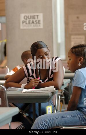 Austin, Texas États-Unis, 14 septembre 2005. Un étudiant de l'Université du Texas à Austin aide les écoliers de Louisiane à faire leurs devoirs dans le refuge de secours de l'ouragan Katrina du Centre de congrès d'Austin. ©Bob Daemmrich Banque D'Images