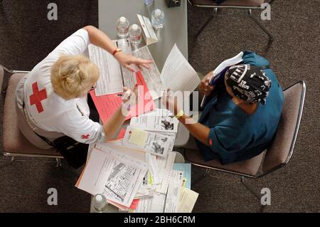 Austin, Texas États-Unis, 10 septembre 2005 : un volontaire de la Croix-Rouge aide la victime de l'ouragan Katrina évacuée sur le site de secours du Centre des congrès d'Austin 12 jours après la chute de la tempête sur la côte du Golfe. ©Bob Daemmrich Banque D'Images