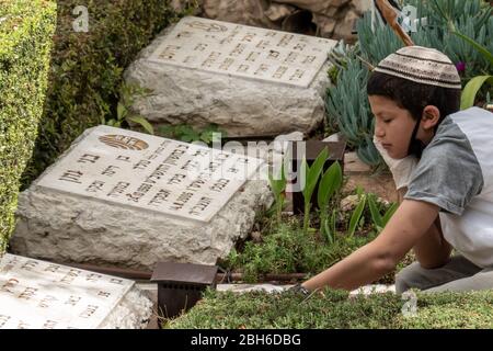 Jérusalem, Israël. 24 avril 2020. Les familles visitent les tombes des morts au Mt. Le cimetière militaire Herzl avant la fête du Souvenir, qui sera commémoré le 28 avril 2020, à la suite de l'annonce par le gouvernement d'un verrouillage total à l'échelle nationale le jour commémoratif lui-même et le lendemain jour de l'indépendance, annulant toutes les cérémonies et célébrations, dans le but de freiner la propagation de la COVID-19. Crédit: NIR Alon/Alay Live News Banque D'Images