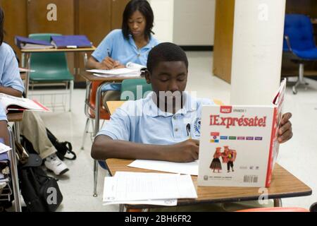 Dallas, Texas, 1 octobre 2008 : des étudiants de neuvième année suivent des cours dans une école secondaire du collège où les étudiants s'engagent par écrit à passer toutes les classes et à suivre un cours de deux ou quatre ans après leur diplôme. Étudiant de sexe masculin noir lisant un manuel en classe espagnole. ©Bob Daemmrich Banque D'Images