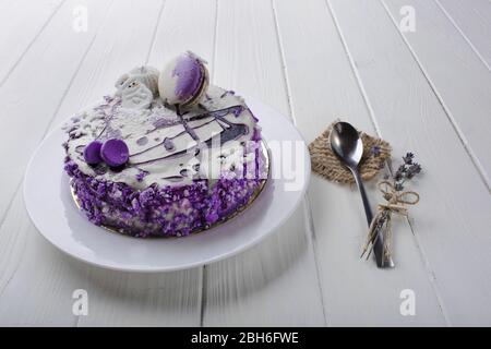 gâteau crémeux avec confiture de bleuets et macaron sur fond de table en bois blanc. Vue de dessus Banque D'Images