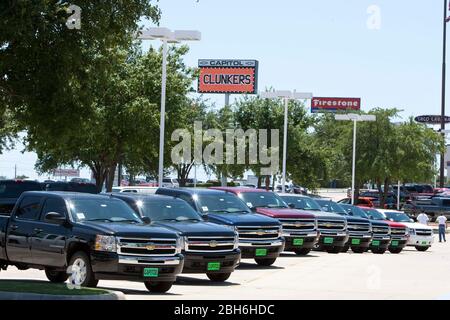 Austin, TX 7 août 2009: De nouvelles voitures sont affichées sous un panneau vantant le programme Cash for Cunkers au Capitol Chevrolet à Austin, en attendant la mise à disposition après la fin des contrats. Les concessionnaires attendent leurs contrôles du gouvernement avant de procéder à la mise au rebut. ©Bob Daemmrich Banque D'Images