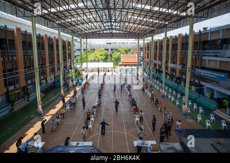 Bangkok, Thaïlande. 24 avril 2020. Les gens attendent en ligne de recevoir des repas gratuits pour aider à lutter contre la perte de revenus due à COVID-19 à l'école Wat Don Muang de Bangkok, Thaïlande. 300 familles ont accepté la nourriture gratuite, avec environ 1500 personnes nourries selon la taille moyenne de la famille. La compagnie aérienne thaïlandaise a facilité la distribution de nourriture pour assurer des mesures sociales adéquates crédit: Andre Malerba/ZUMA Wire/Alay Live News Banque D'Images