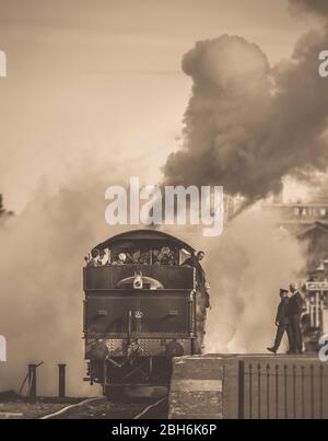 Vue sur la sépia du train à vapeur britannique vintage, depuis l'arrière, en quittant la gare de Kidderminster Severn Valley. Banque D'Images