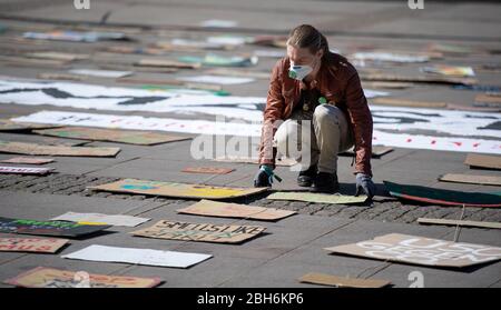 Hambourg, Allemagne. 24 avril 2020. Un militant du vendredi pour l'avenir expose des panneaux et des affiches lors d'une action sur le marché de la mairie. Crédit: Daniel Reinhardt/dpa/Alay Live News Banque D'Images