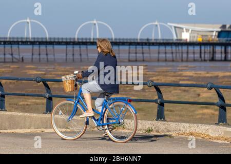 Southport, Merseyside. Météo britannique. 24 avril 2020. Une autre journée ensoleillée de printemps dans le complexe, alors que les habitants de la région prennent des exercices légers. Femme équitation Ryedale femmes shopper vélo sur la promenade du front de mer. Crédit: MediaWorldImages/AlamyLiveNews Banque D'Images
