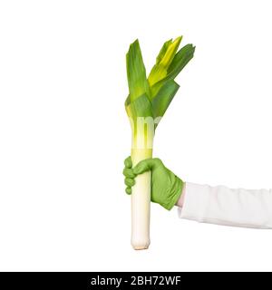 La main féminine dans le gant jetable maintient la poireau. Hygiène dans le concept de cuisine Banque D'Images
