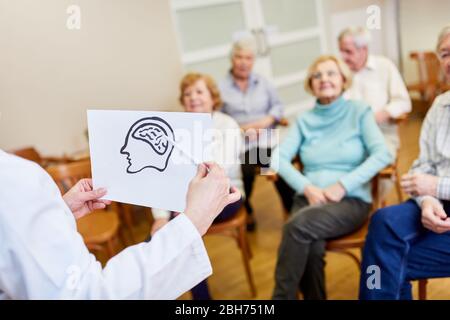 Le président avec un dessin du cerveau explique la maladie d'Alzheimer aux aînés Banque D'Images