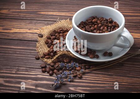 Tasse avec café noir, grains de café et branches de lavande sur un plan d'examen en bois. Vue de dessus Banque D'Images