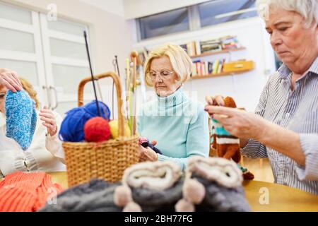 Les aînés se crocheent ensemble dans un cours d'artisanat ou comme passe-temps dans la réunion de haut niveau Banque D'Images