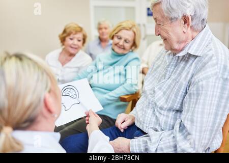 Le médecin en tant que conférencier explique la maladie de démence aux personnes âgées dans un séminaire Banque D'Images