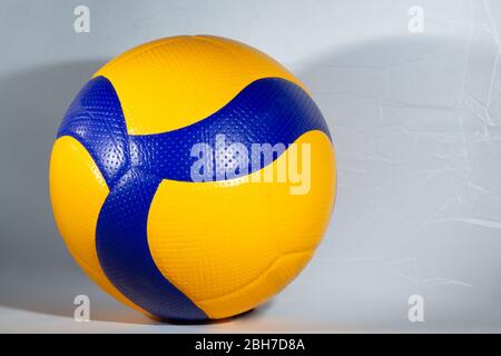 Boule bleue et jaune pour jouer au volley sur fond blanc Banque D'Images