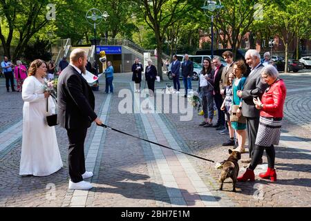 Dortmund, 24 avril 2020: Mariage à Corona Times. Un couple s'est marié le 24 avril. Devant le bureau du registre, les membres de la famille et les amis les ont félicités à distance de sécurité appropriée. Banque D'Images