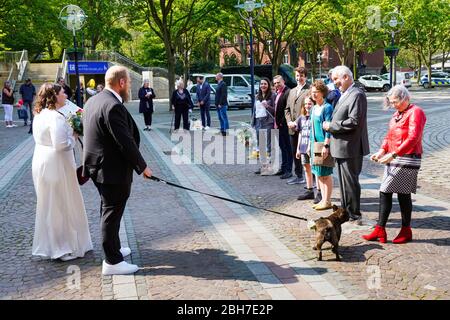 Dortmund, 24 avril 2020: Mariage à Corona Times. Un couple s'est marié le 24 avril. Devant le bureau du registre, les membres de la famille et les amis les ont félicités à distance de sécurité appropriée. Banque D'Images