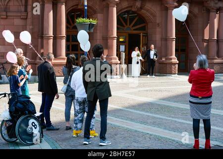 Dortmund, 24 avril 2020: Mariage à Corona Times. Un couple s'est marié le 24 avril. Devant le bureau du registre, les membres de la famille et les amis les ont félicités à distance de sécurité appropriée. Banque D'Images