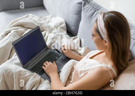 Vue latérale supérieure d'une femme avec plappage et carte de crédit dans l'intérieur de la maison. Concept d'achat en ligne. Banque D'Images