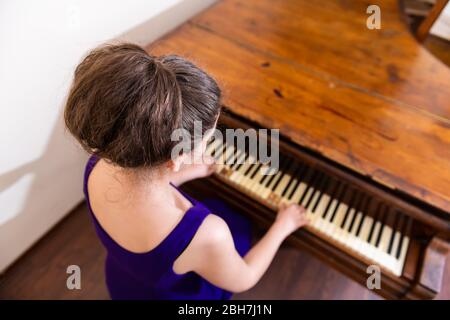 Piano à la vieille forte jeune fille assise pianiste jouant en costume en Europe pour concert au-dessus de la vue abstraite Banque D'Images