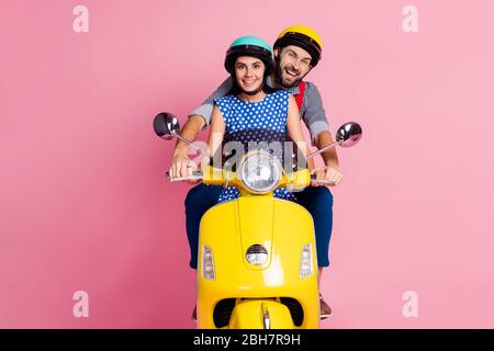 Portrait de son il elle belle jolie gaie couple conduite cyclomoteur passer du temps vacances week-end isolé sur couleur pastel rose Banque D'Images