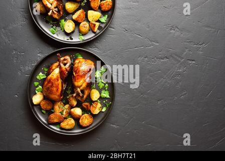 De délicieuses carcasses de cailles grillées avec pommes de terre cuites sur fond de pierre noire avec espace libre pour le texte. Vue sur le dessus, plat Banque D'Images