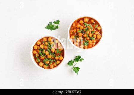 Pois chiches cuits de style indien dans un bol sur fond blanc avec espace texte libre. Concept de cuisine végétarienne. Vue sur le dessus, plat Banque D'Images