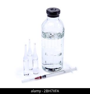 ampoules médicales en verre scellées avec liquide clair, flacon de solution saline et seringue isolées sur fond blanc Banque D'Images