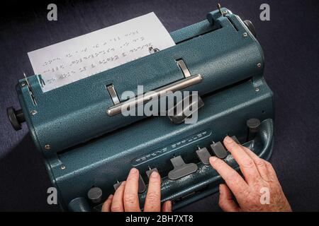 Une femme qui tape en braille à l'aide d'une machine à écrire Perkins Brailler. Banque D'Images