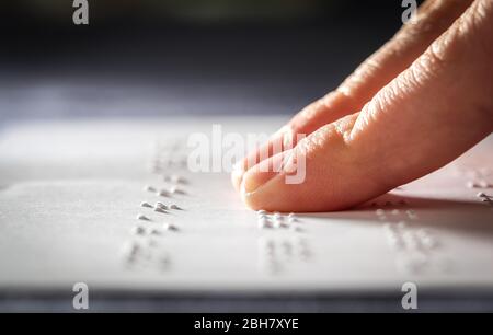 Un élève d'école d'adolescence lisant le texte de braille avec ses doigts Banque D'Images