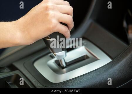 Gros plan sur la conduite d'une femme tenant la main sur la conduite automatique du levier de vitesses en voiture. Banque D'Images