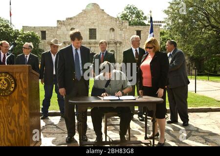 San Antonio Texas États-Unis, 15 juin 2009: Le gouverneur du Texas Rick Perry signe une loi protégeant les propriétaires du Texas lors d'une cérémonie devant l'Alamo. Le bras droit de Perry est dans une élingue après qu'il a cassé sa clavicule lors d'un accident de vélo. ©Marjorie Kamys Cotera/Bob Daemmrich Photographie Banque D'Images