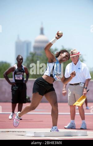 Austin Texas États-Unis, 6 juin 2009 : le putter féminin se prépare à lancer l'événement de tir avec le capitole du Texas en arrière-plan lors des championnats de l'État du lycée du Texas sur piste au stade de l'université du Texas. ©Bob Daemmrich Banque D'Images