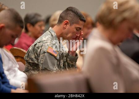 Killeen, Texas États-Unis, 8 novembre 2009: Le PFC Cameron Parrott tient la main à son visage lors d'un service commémoratif à la première église baptiste de Killeen, trois jours après que l'homme armé accusé Nidal Hasan a ouvert le feu au poste de l'armée de fort Hood tout proche, tuant 13 personnes et blessant beaucoup plus. ©Bob Daemmrich Banque D'Images