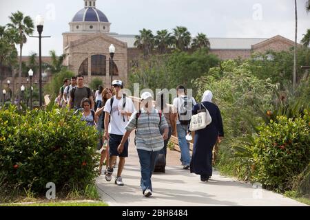 Brownsville, Texas, États-Unis, 8 octobre 2009: Principalement des étudiants hispaniques de l'université marchant vers des classes avec les écoles d'éducation et de commerce dans l'arrière-plan à l'Université du Texas-Brownsville/Texas SouthMOST College campus. ©Bob Daemmrich Banque D'Images