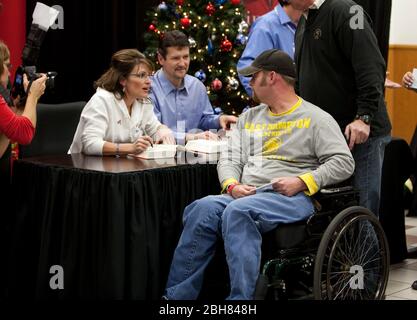 Fort Hood Texas États-Unis, 5 décembre 2009: L'ancienne gouverneure de l'Alaska Sarah Palin signe une copie de son livre, 'Going Rogue', pour les soldats à la poste avec le mari Todd (à droite), un mois après que l'homme armé Nidal Malik Hasan aurait tué 13 personnes dans un rampage de tir sur la base. Palin est sur une tournée de livres de plusieurs villes américaines et a fait un détour pour rencontrer et saluer les soldats au poste de l'Armée de terre. ©Bob Daemmrich Banque D'Images